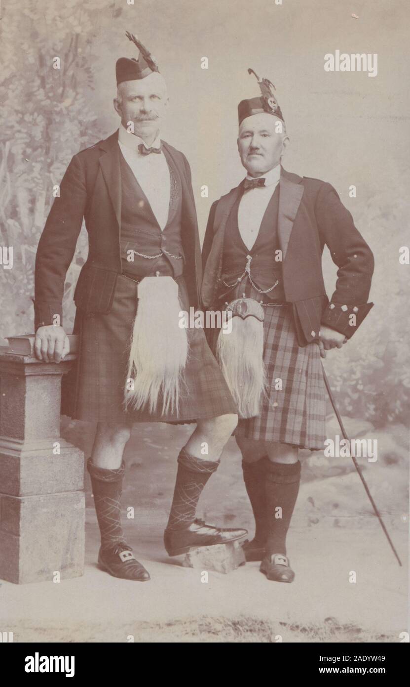 Vintage Anfang des 20. Jahrhunderts Fotopostkarte im Studio zeigt zwei schottische Männer, die ihre Kilts und Sporran tragen. Stockfoto