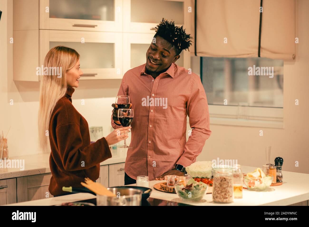 Freundliche Mann lächelnd zu seiner Freundin und Wein trinken mit ihr Stockfoto