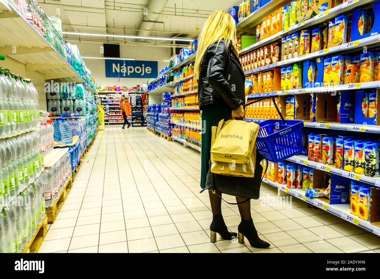 Frau einkaufen wählt Säfte in Supermarktregalen, Tesco-Shop Stockfoto