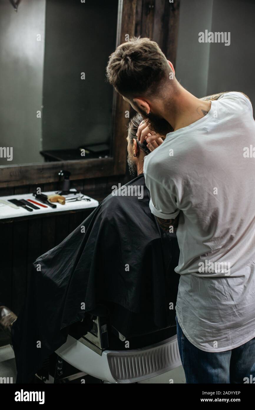 Taille von Friseur berühren dunkle Haar auf seinem Client Stockfoto