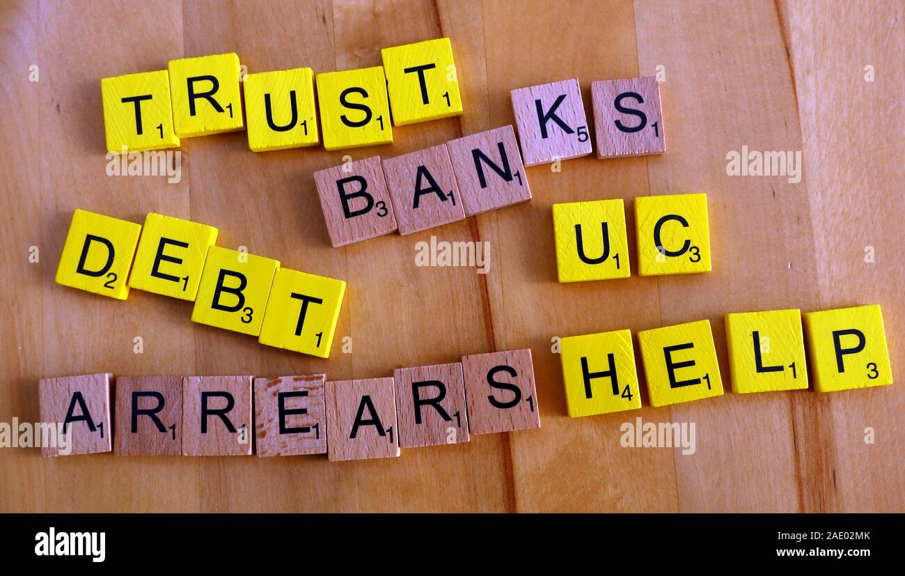 Scrabble-Buchstaben, Wörter, Treuhandkonten, Banken, Schulden, Rückstände, Hilfe, UC, Universal Credit – Probleme, auf die arme Einwohner stoßen Stockfoto