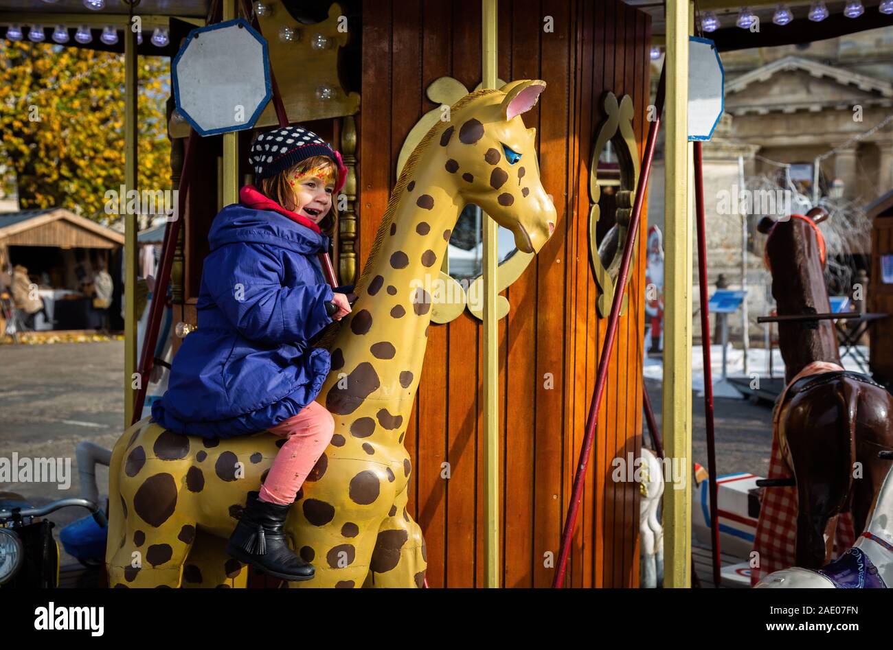 Süß lächelnde Mädchen auf der Merry-go-round, Schuß in Frankreich Stockfoto