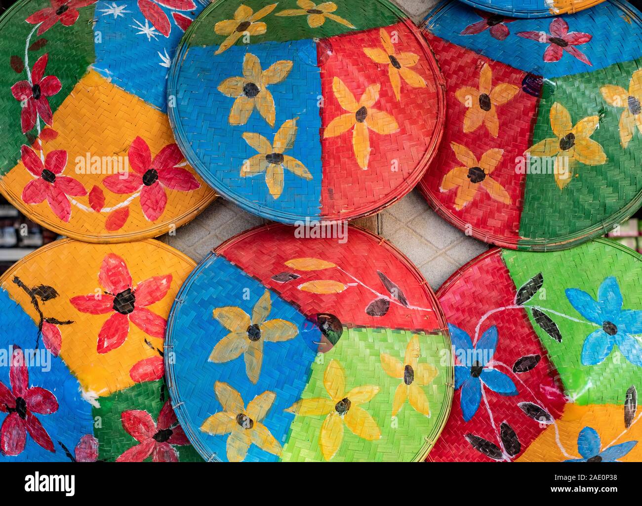 Farbenfroh Hüte der konischen Landwirt lackiert mit Blumenmotiven und hellen Primärfarben ein Geschäft entlang der Chindwin Fluss schmücken in Myanmar (Birma) Stockfoto