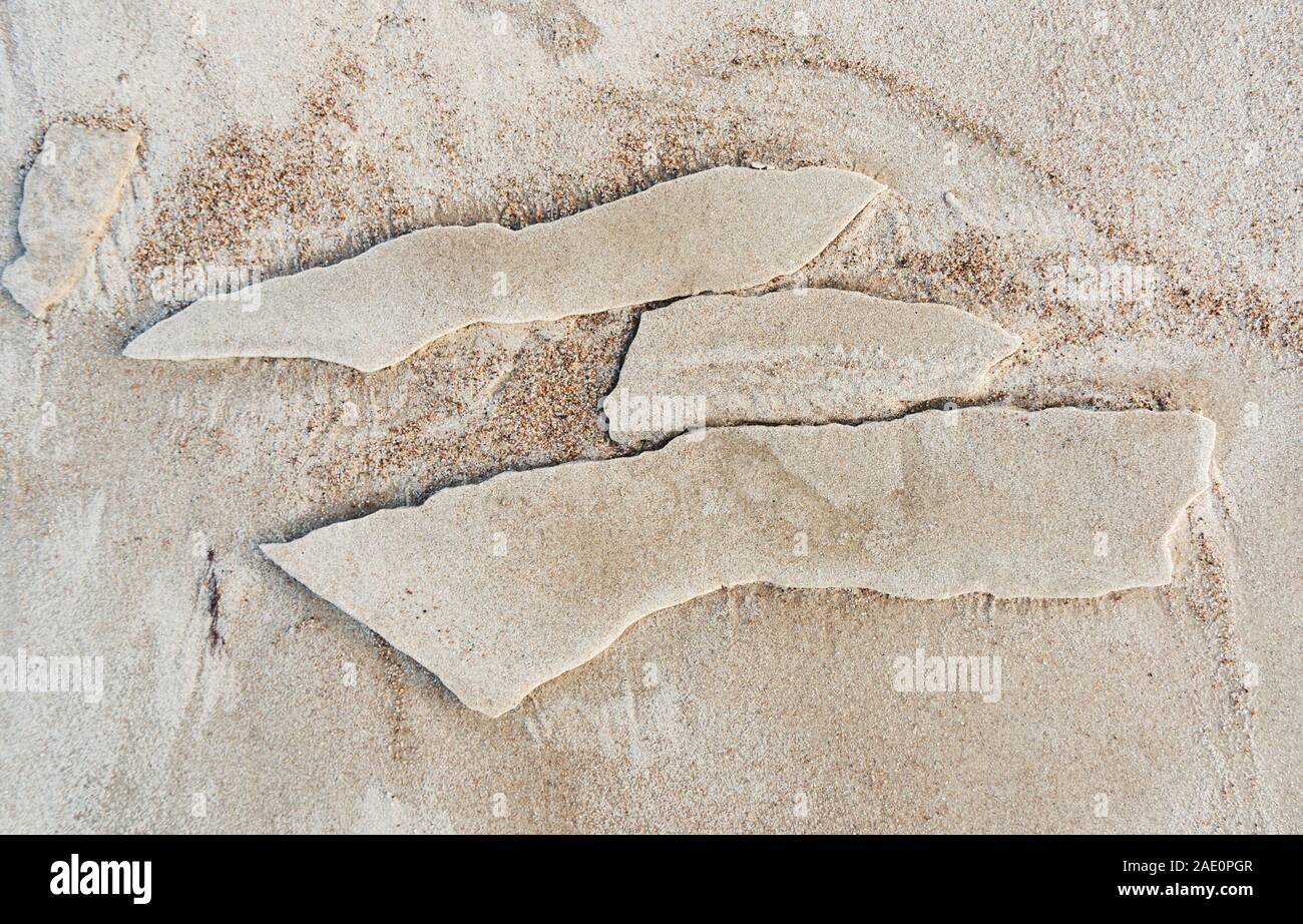Strand Hintergrund mit gebrochenen frosted Stück nassem Sand. Stockfoto