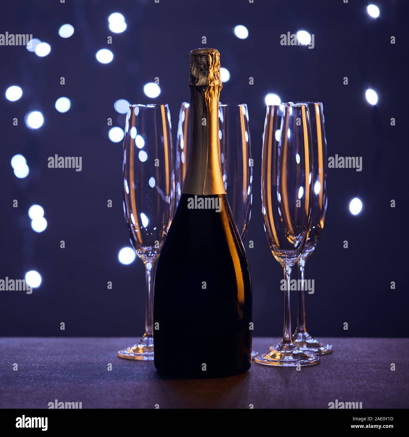 Flasche Champagner und Gläsern mit Weihnachtsbeleuchtung bokeh Stockfoto