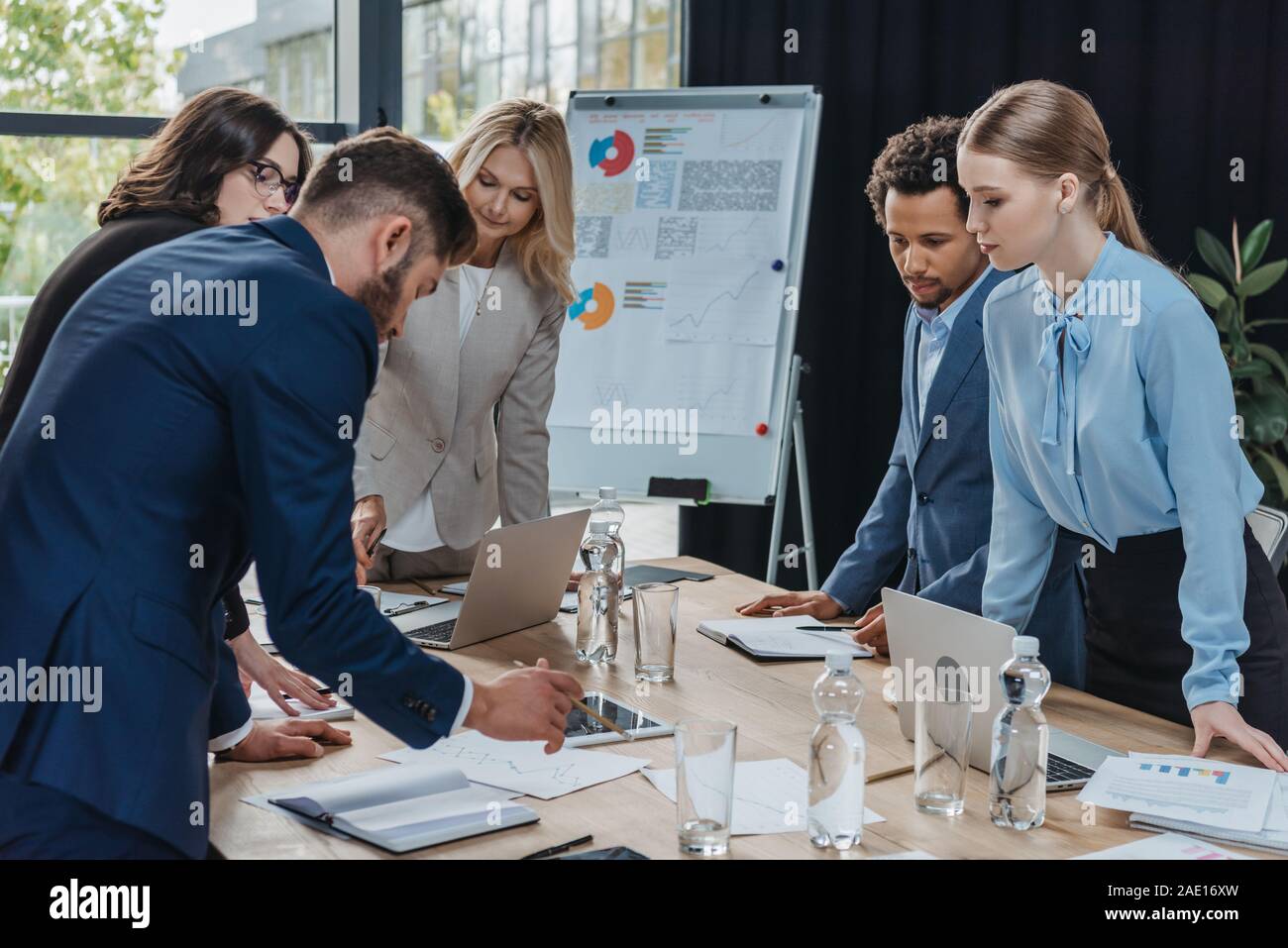 Multikulturelle Geschäftsleute auf Dokument auf Schreibtisch während der Konferenz Stockfoto