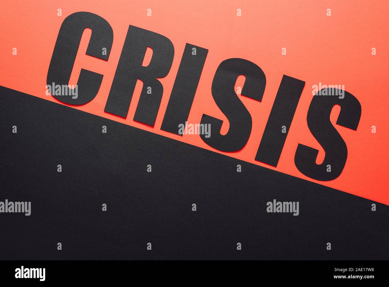 Draufsicht auf das Wort Krise auf schwarzem und rotem Hintergrund von schräge Linie geteilt Stockfoto