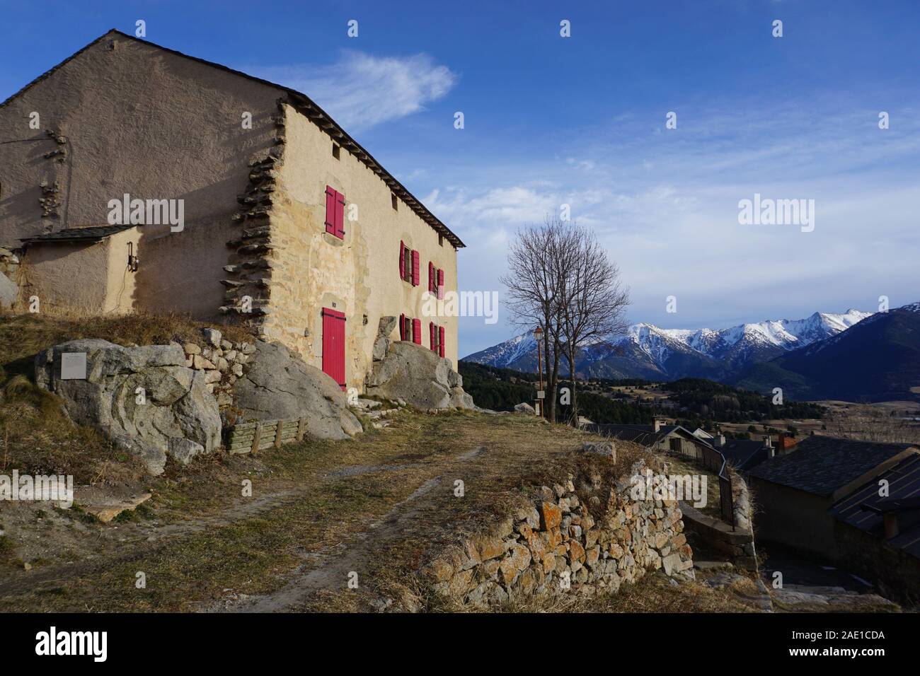 Typische alte Steinhaus auf einem Hügel in den Bergen von Frankreich mit einem breiten Panorama und roten Fensterläden Stockfoto