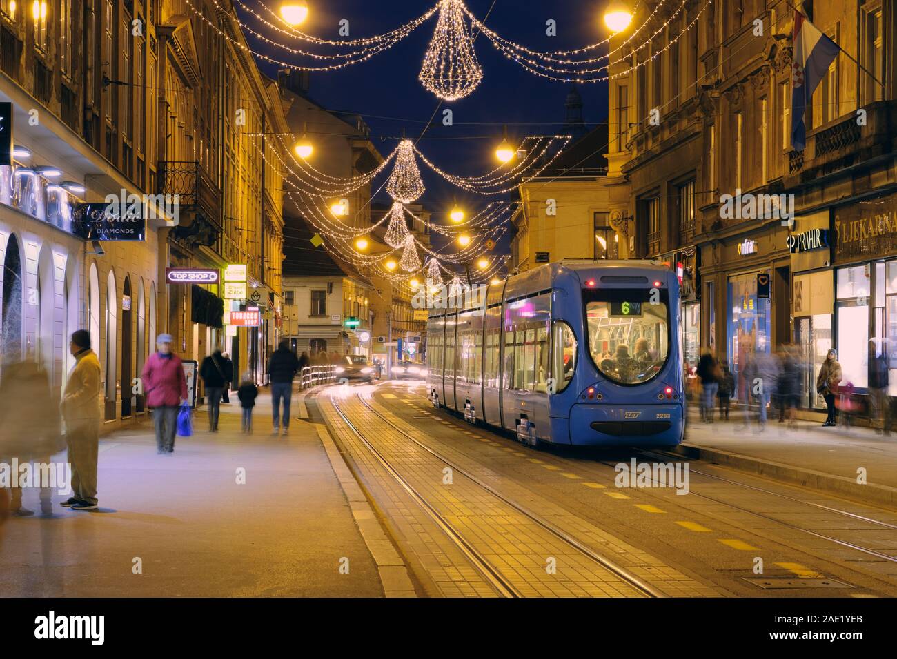 Weihnachtsbeleuchtung auf der Straße in der Nacht, mit der Straßenbahn gestoppt und Verbringung von Personen mit langer Belichtungszeit. Zagreb Kroatien. Stockfoto