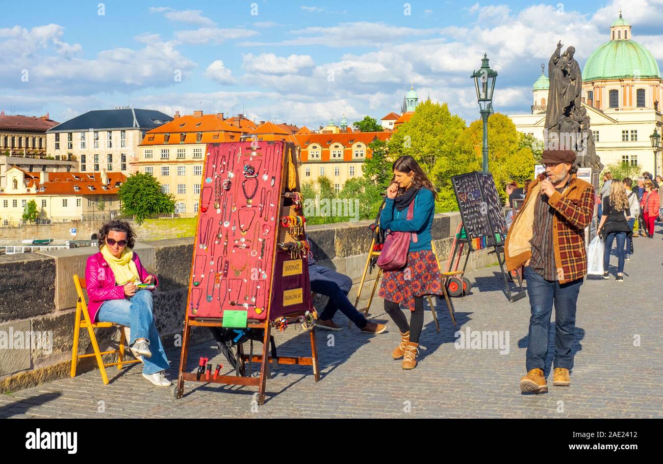 Straßenhändler mit Souvenirs und Schmuck für Touristen auf der Karlsbrücke in Prag in der Tschechischen Republik. Stockfoto