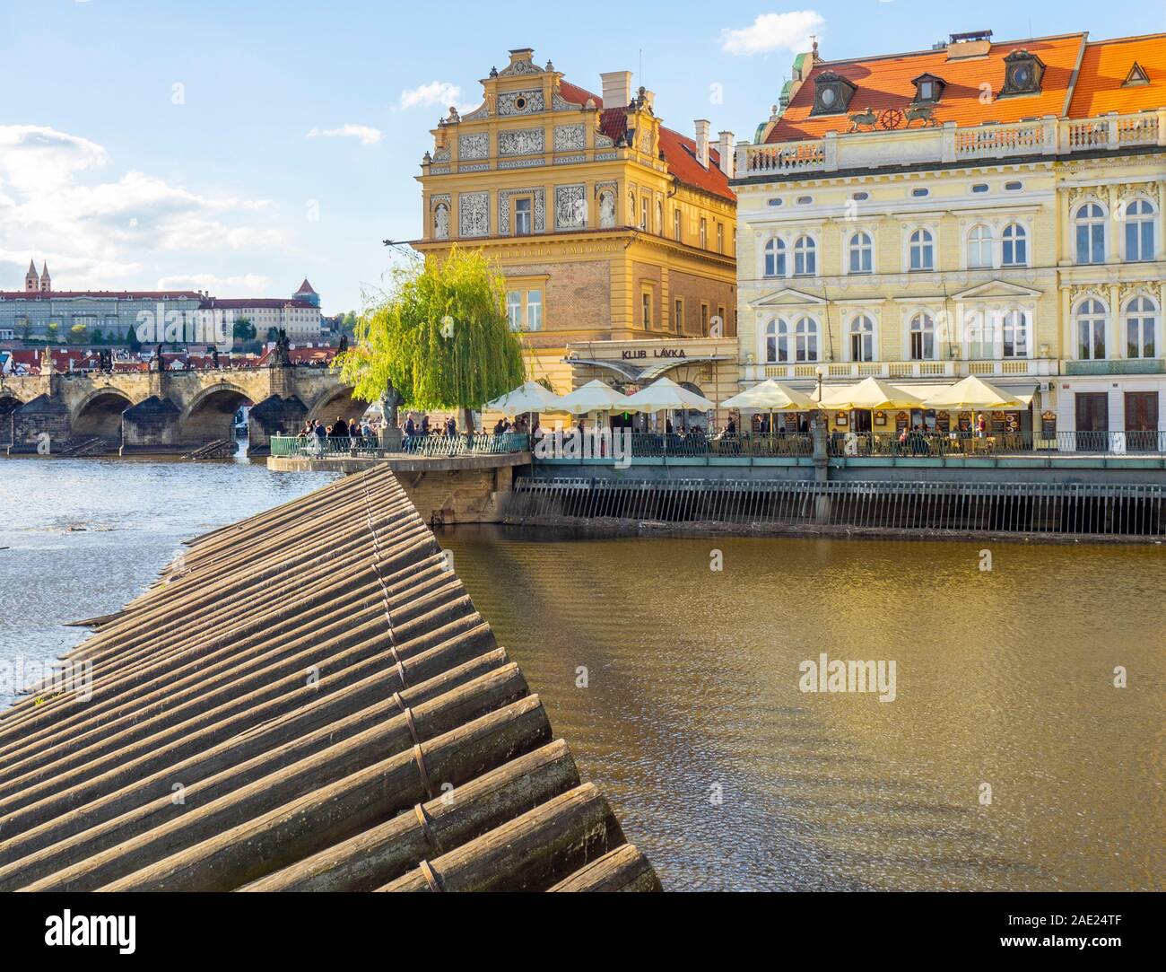 Holz- Protokolle fest auf einem Damm in der Moldau und Lavka club und Bedřich Smetana Museum in Prag in der Tschechischen Republik Stockfoto