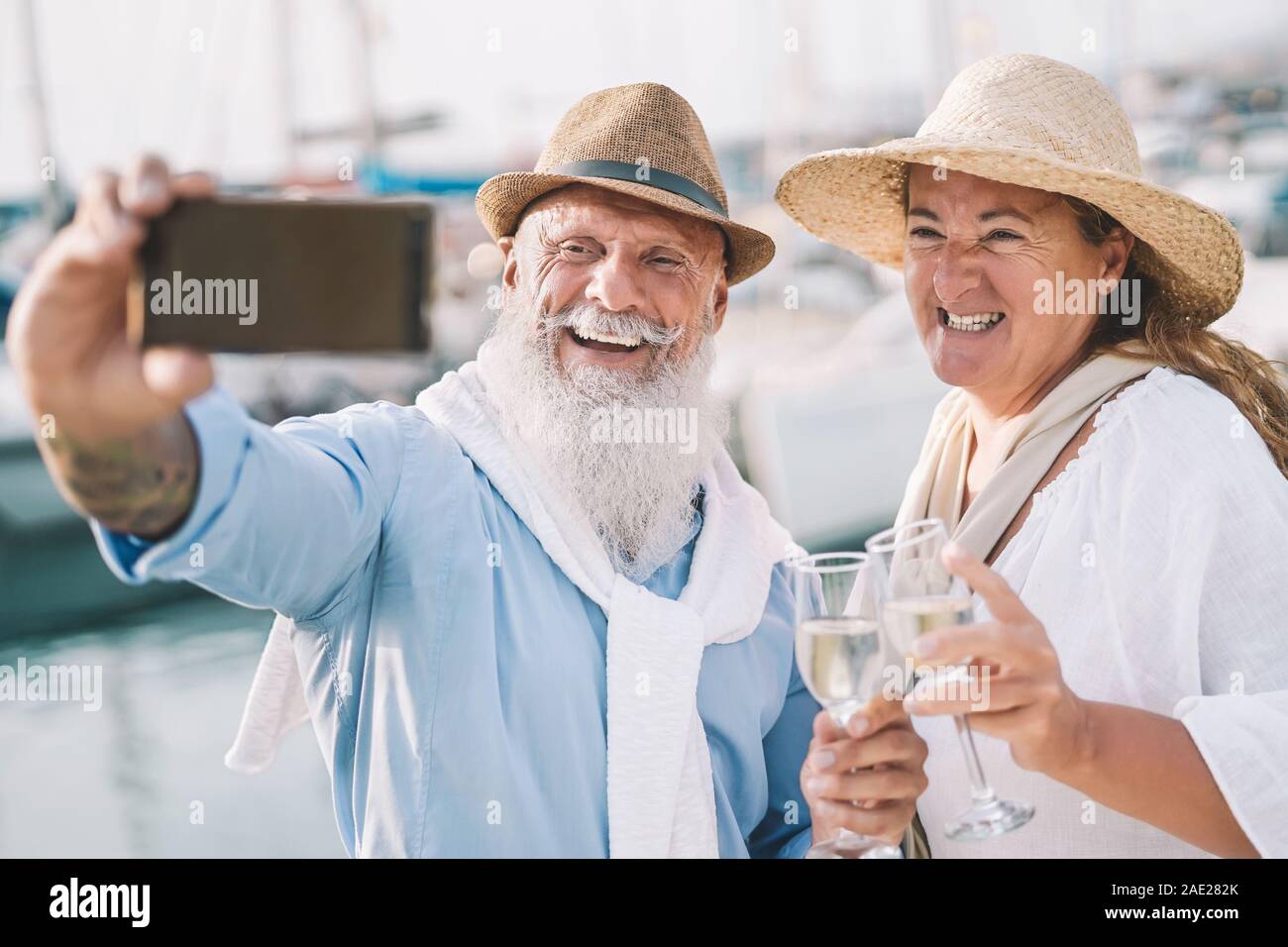 Senioren Paar unter selfie mit Mobile Smartphone auf Segelboot Urlaub - glückliche Menschen Spaß haben, trinken Champagner auf Bootsfahrt zu feiern Stockfoto Senioren Paar unter selfie mit Mobile Smartphone auf Segelboot Urlaub - glückliche Menschen Spaß haben, trinken Champagner auf Bootsfahrt zu feiern Stockfoto
