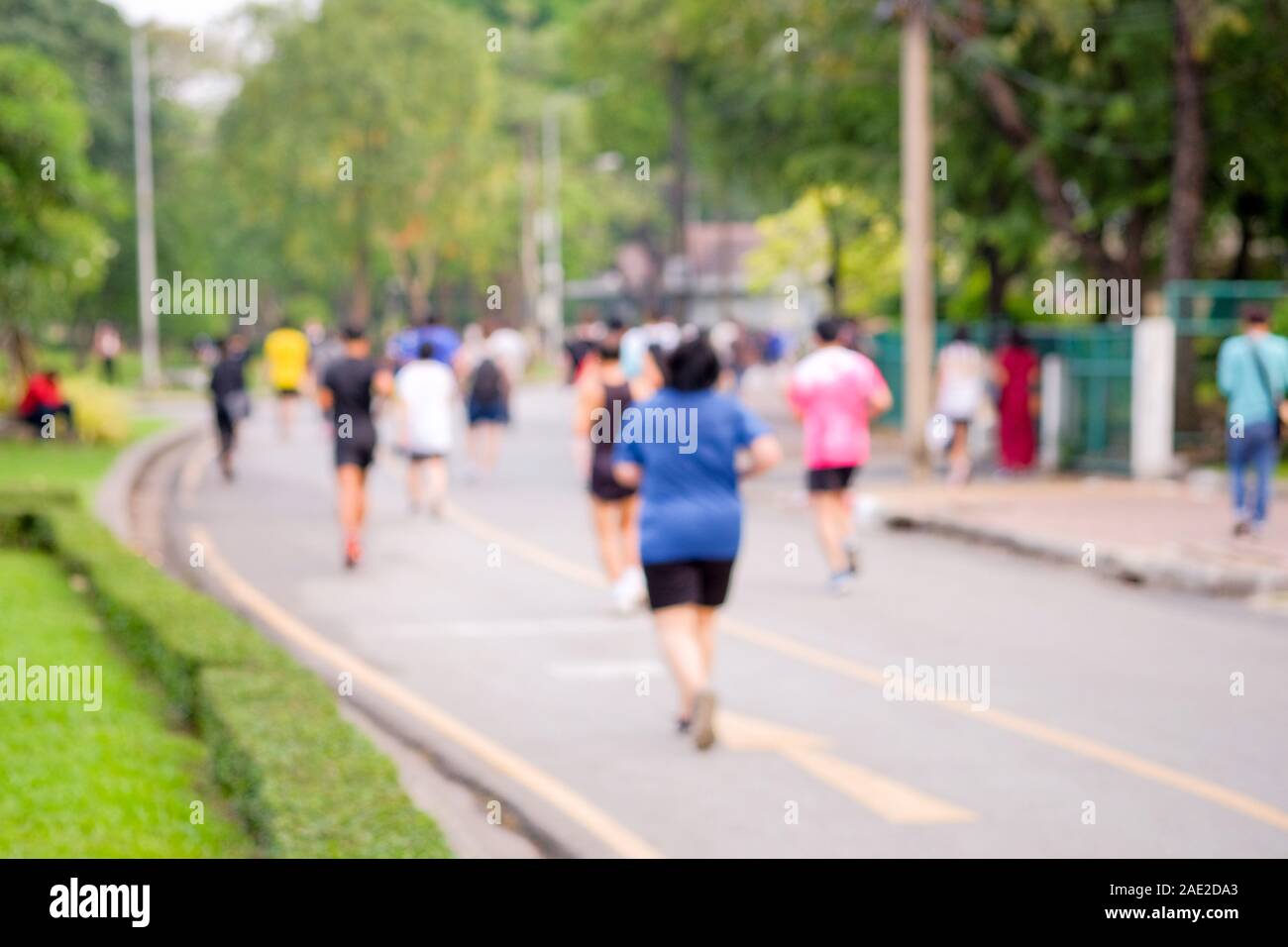 Ansicht von hinten und verschwommenes Bild von Menschen, die beim Joggen in den öffentlichen Park am Abend nach der Arbeit. Stockfoto