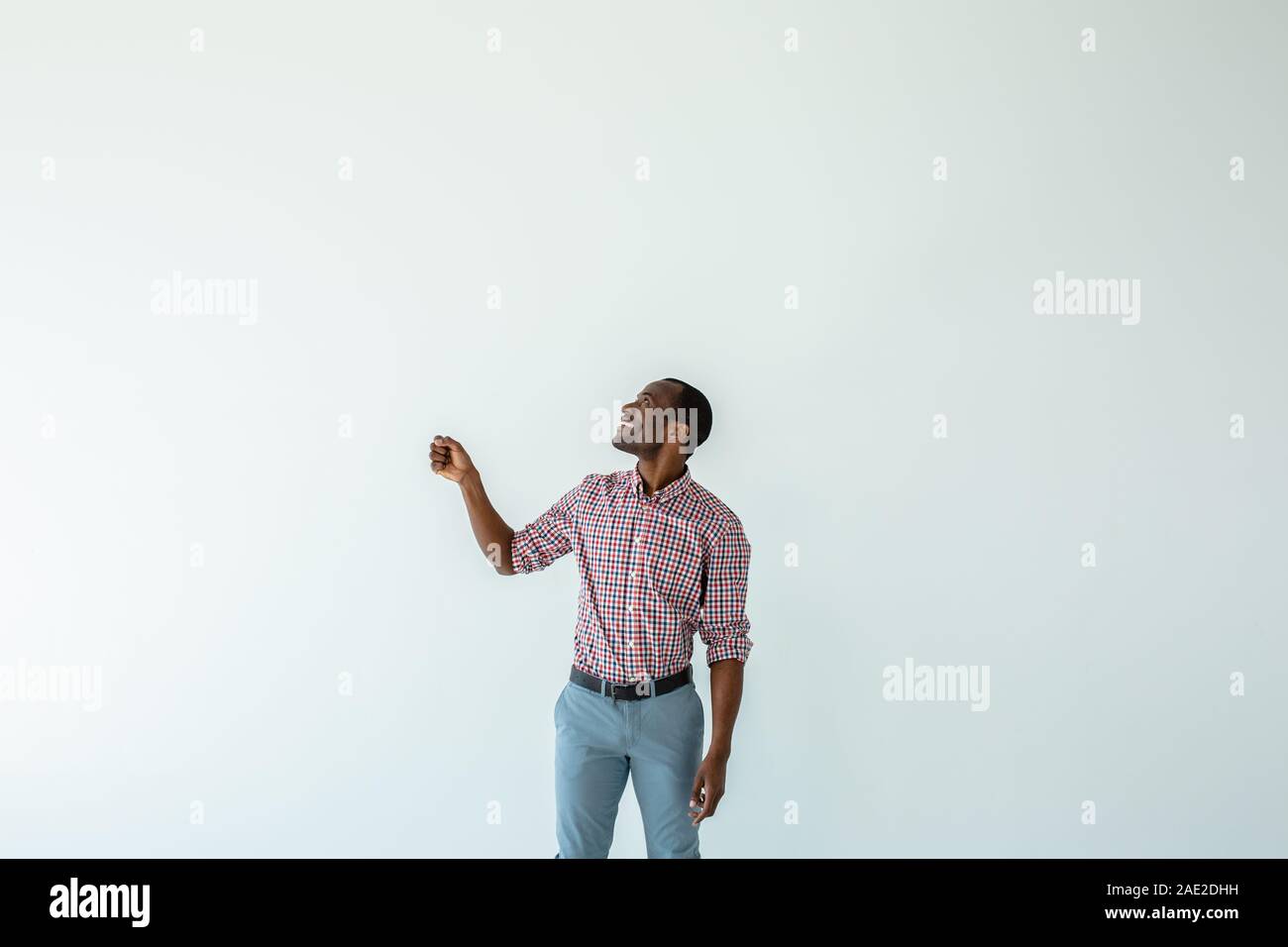 Fröhliche afro-amerikanische Mann hält einen Regenschirm Stockfoto