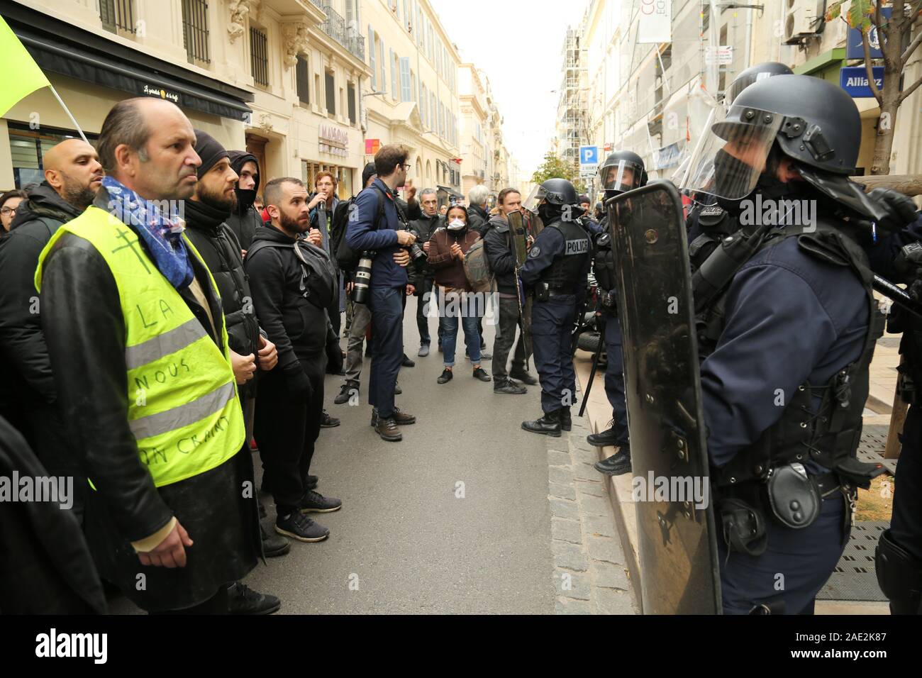 Marseille, Frankreich. 05 Dez, 2019. Die Demonstranten mit Polizeibeamten zu Gesicht während der nationalen Streik gegen die Rentenreform von Präsident Längestrich Pläne in der Stadt Marseille. Mehr als 150, 00 Demonstranten seit März am Donnerstag gegen die Pläne der Regierung für eine neue universelle Punkte-basierten System der Altersversorgung. Der Streik wurde von mehr als 30 Gewerkschaften organisiert für Präsident Emmanuel Längestrich, seine Pläne für die Rentenreform zu bewerten. Credit: ZUMA Press, Inc./Alamy leben Nachrichten Stockfoto