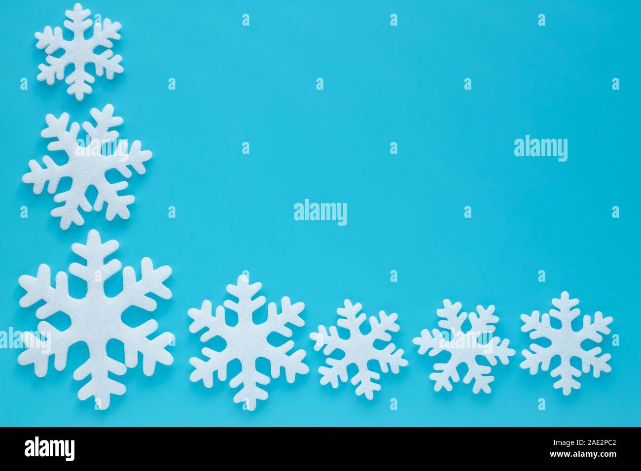 Zusammensetzung der Schnitt weiß Schneeflocken auf blauem Hintergrund in abstrakten Stil. Tapeten Muster. Frohe Weihnachten Hintergrund. Rahmen mit Schnee Effekt. Flatl Stockfoto