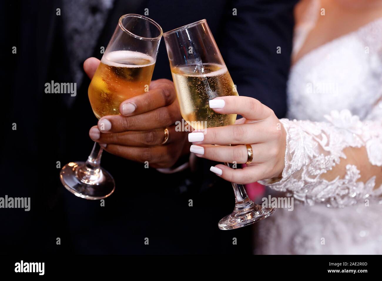 Hand Detail mit Hochzeit Ringe und Champagner Gläser - pflegt Toast - Goldene Hochzeit Ringe Stockfoto