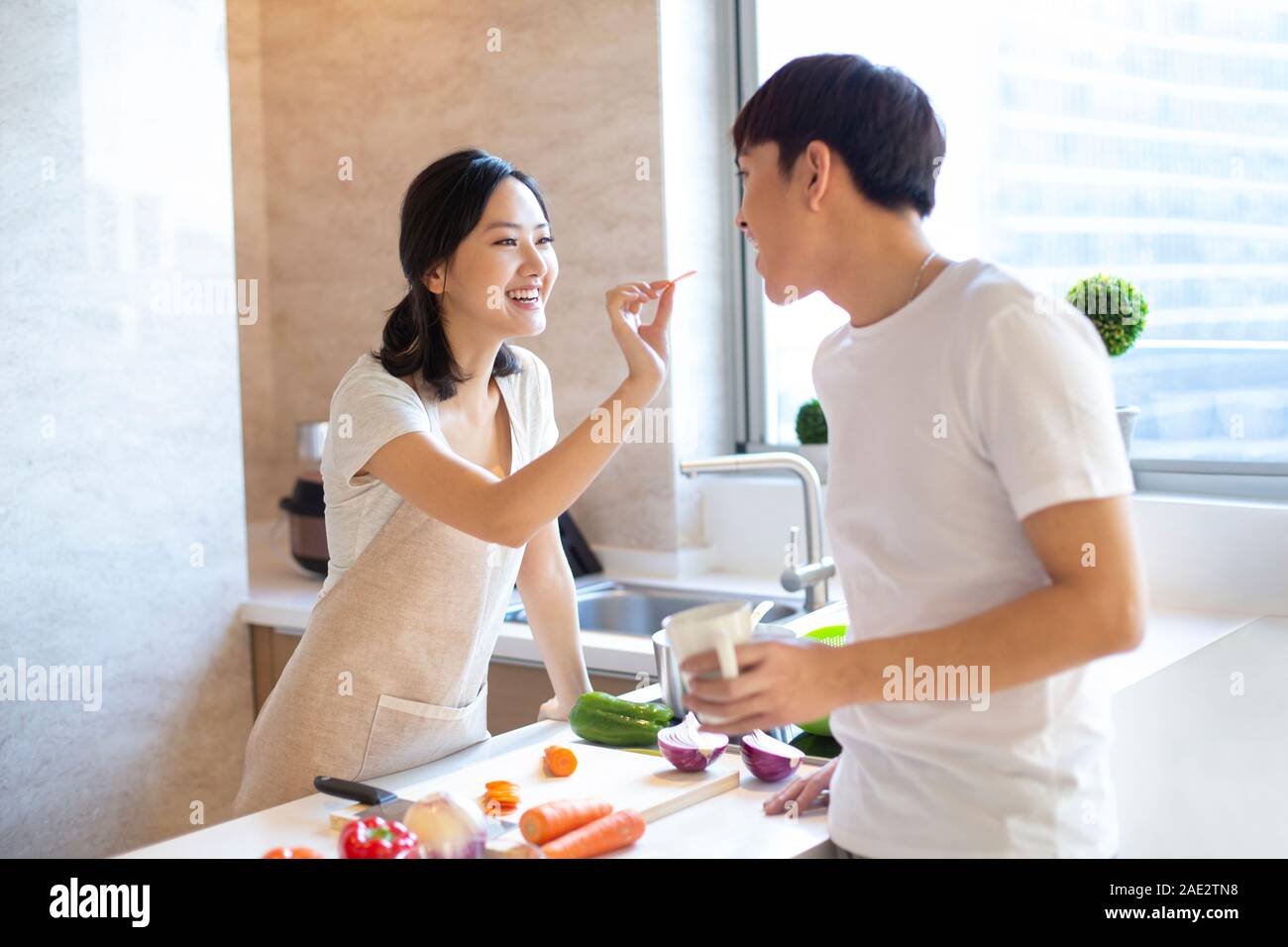 Freundin Fütterung Freund in der Küche Stockfoto