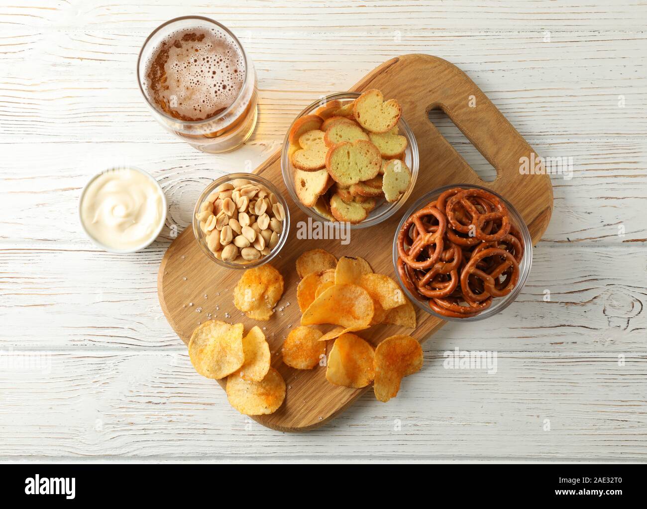 Chips, Bier, Bier, Snacks, Bier, Muttern, Saucen auf weißem Hintergrund Holz, Platz für Text. Ansicht von oben Stockfoto