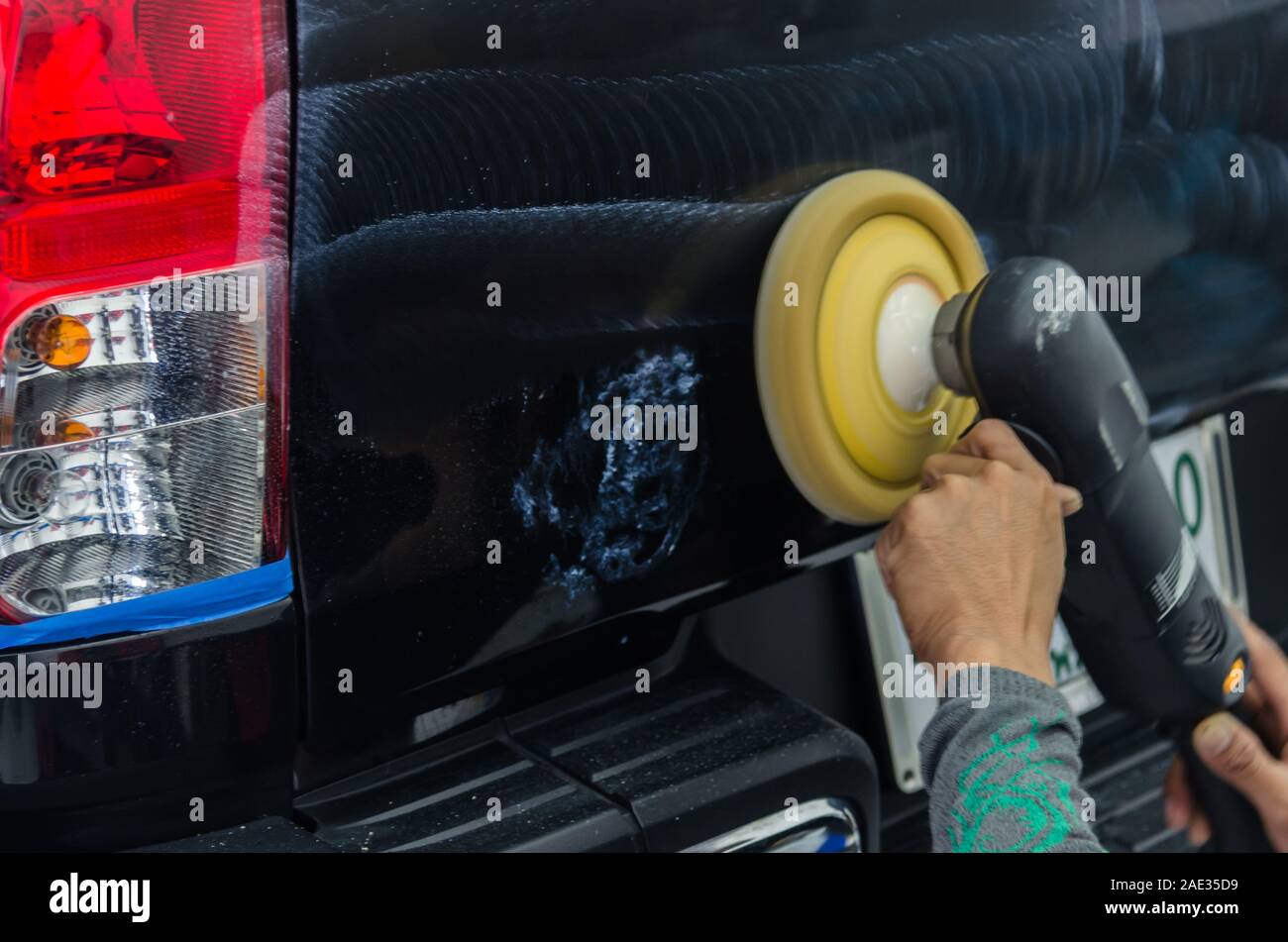 Schwarzes auto Kratzer entfernen. Ein Mann hält ein Auto polieren Werkzeug  in der Garage Stockfotografie - Alamy