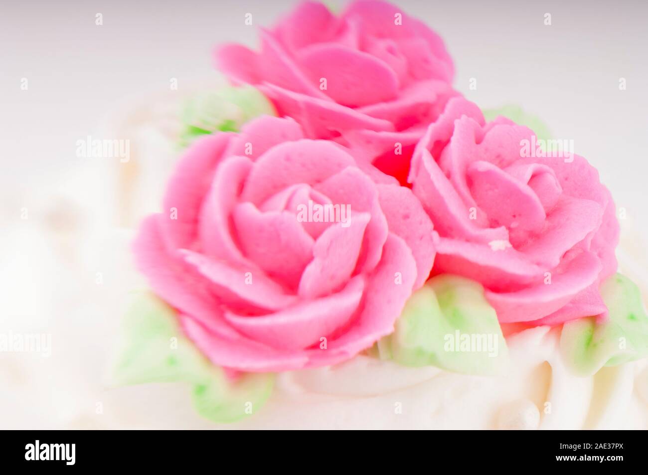 Weiß und rosa Kuchen Glasur Detail mit dekorativen Blumen Stockfoto
