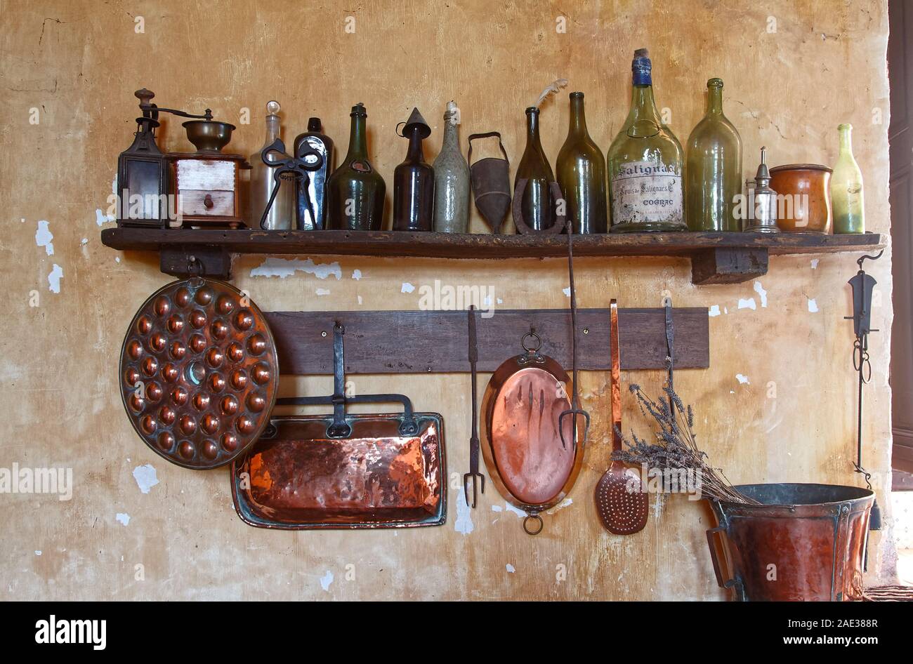 Küche, Flaschen und Geräte, alten Holz Regal, Kupfer Pfannen hängen, an der Wand die Farbe blätterte ab, Zimmer, Chateau Courmatin; Schloss aus dem 17. Jahrhundert; Burgund; Taiz Stockfoto