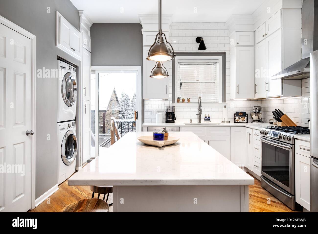 Eine luxuriöse Küche mit Edelstahlgeräten und hellem Holz ausgestattet. Die Ansicht zeigt eine Szene. Stockfoto