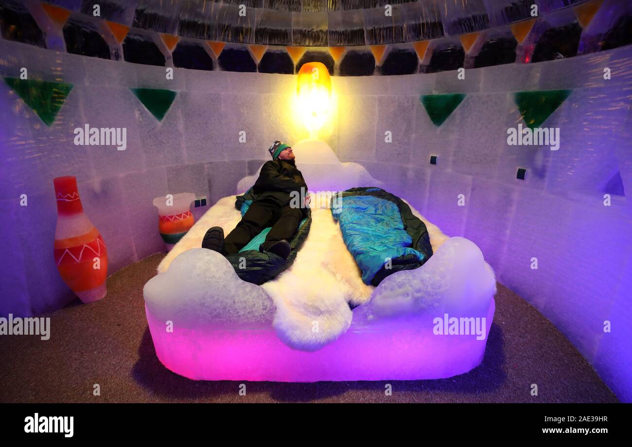 Rovershagen, Deutschland. 06 Dez, 2019. Nach der Eröffnung des 17. Ice World in Karls Erlebnis-Dorf, ein Besucher liegt im Bett im Ice Hotel in der Ausstellung "Afrika - Expedition zum Kilimanjaro". 25 Künstler aus 12 Ländern verarbeitet ca. 300 Tonnen Eis aus einem polnischen Ice Factory. Die Ausstellung ist geöffnet bis 01.11.2020. Quelle: dpa Picture alliance/Alamy leben Nachrichten Stockfoto