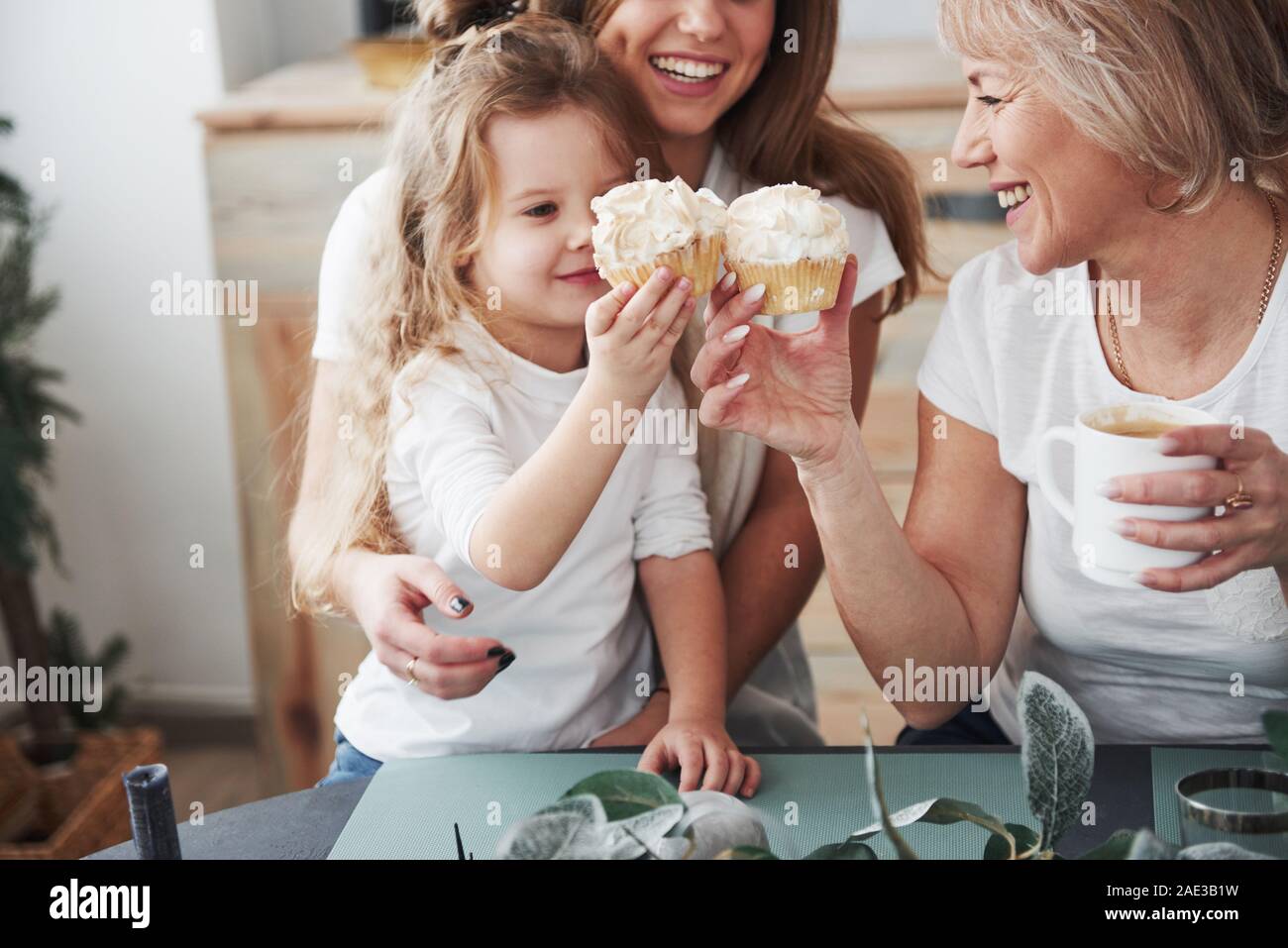 Einen Toast mit kleinen Kuchen. Mutter, Großmutter und Tochter eine gute Zeit in der Küche Stockfoto