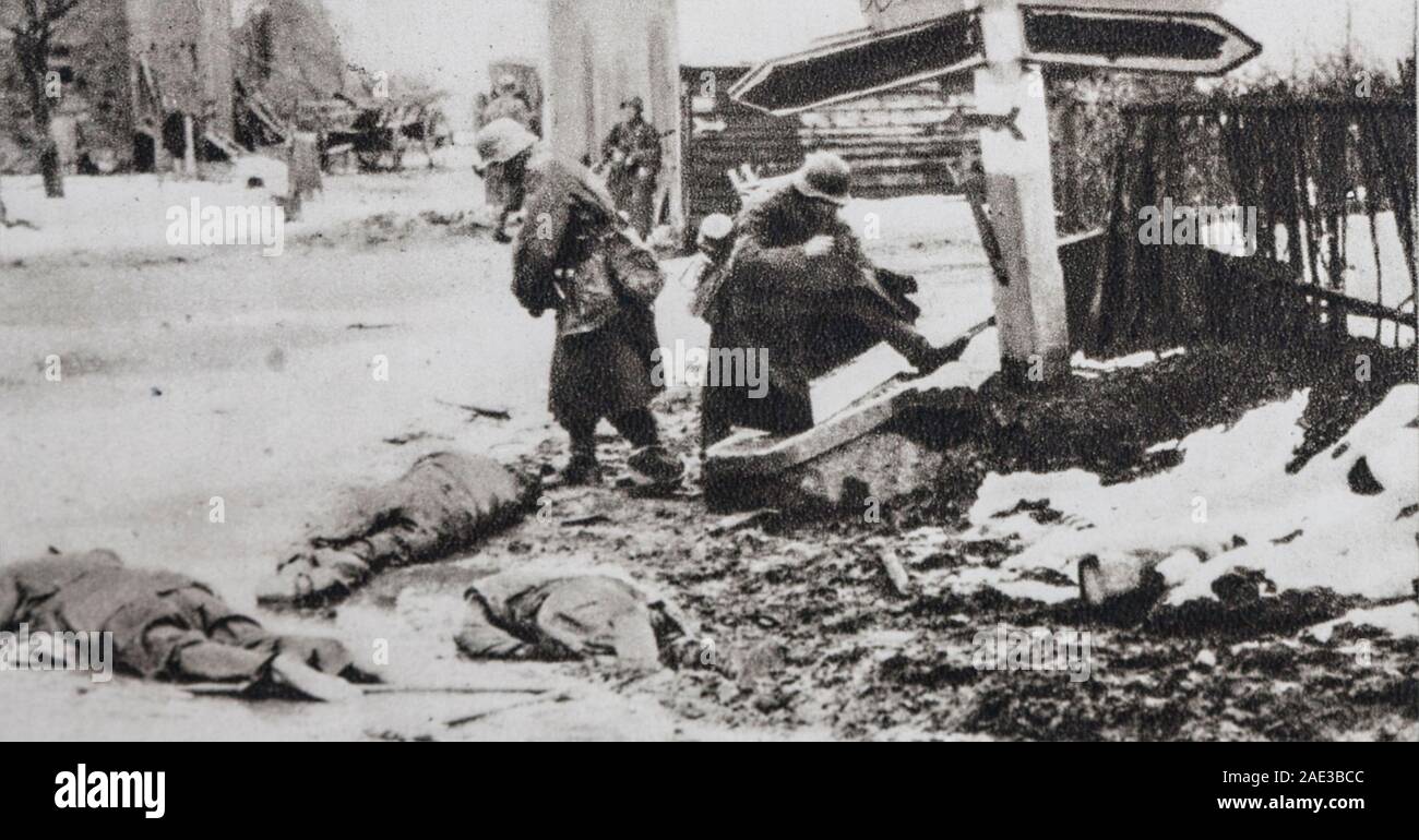 Die offensive in den Ardennen. Deutsche Soldaten streifen die Körper der amerikanischen Soldaten, ihrer Schuhe und Ausrüstung. Stockfoto