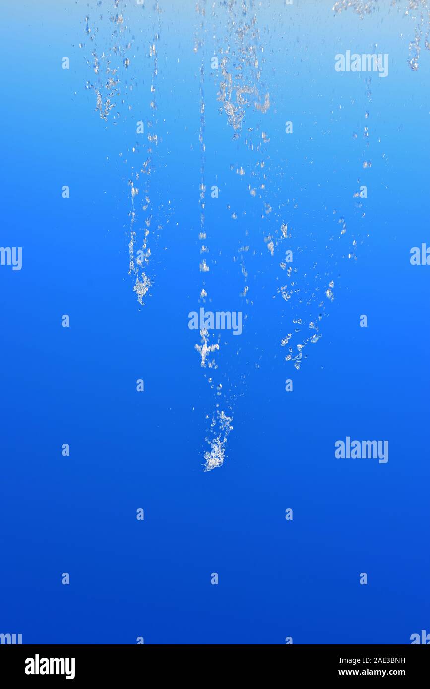 Strom der Wassertropfen aus einem Brunnen gegen den blauen Himmel. Stockfoto