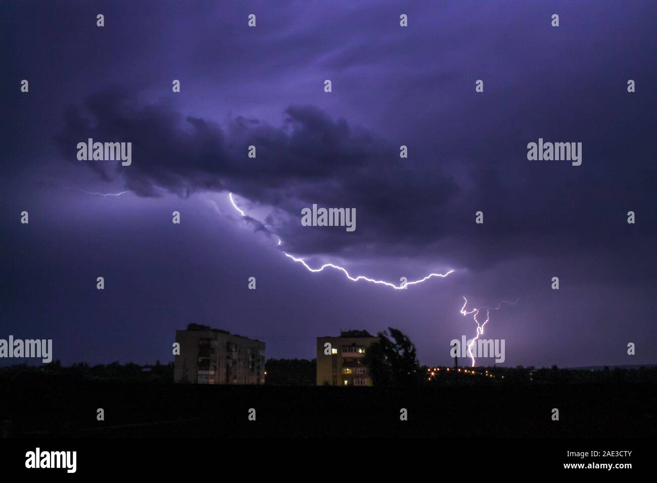 Blitz in große Wolke über Nacht Stadt. Schwarz stürmischen Kulisse. Thunderstorm Wetter. Himmel Wolken. Dunkle dramatische Szene. Nacht Gewitter Sturm. Stockfoto