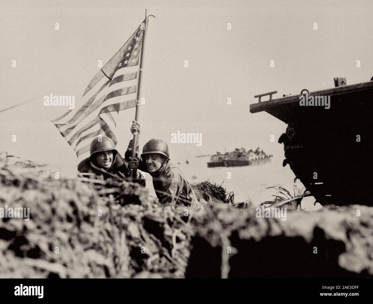 Erste Flagge auf Guam auf bootshaken Mast. Zwei US-amerikanische Offiziere Werk der amerikanischen Flagge auf Guam acht Minuten nach U.S. Marines und Armee Angriff Truppen lande Stockfoto