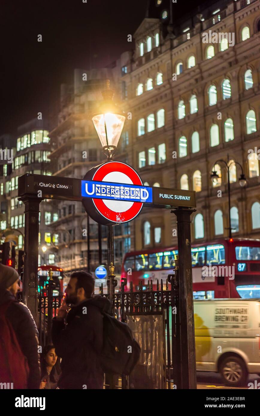 U-Bahn-Schild in London an der U-Bahn-Treppe, Eingang zur Charing Cross Station am Trafalgar Square, im Zentrum von London, Großbritannien, nachts mit Straßenbeleuchtung beleuchtet. Stockfoto