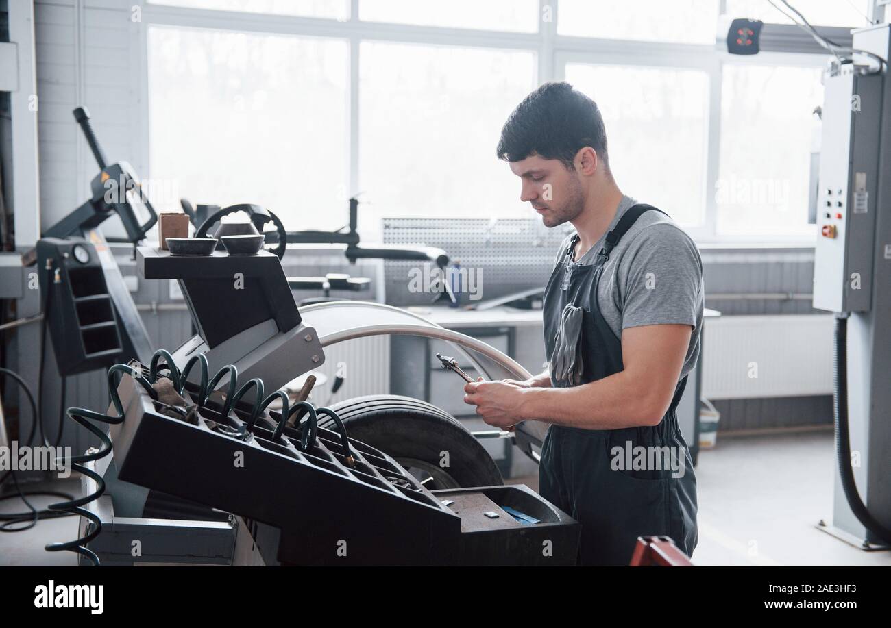 Dieses Instrument wird gut sein. Junge Mann arbeitet mit's Rad Festplatten auf den Workshop am Tag Stockfoto