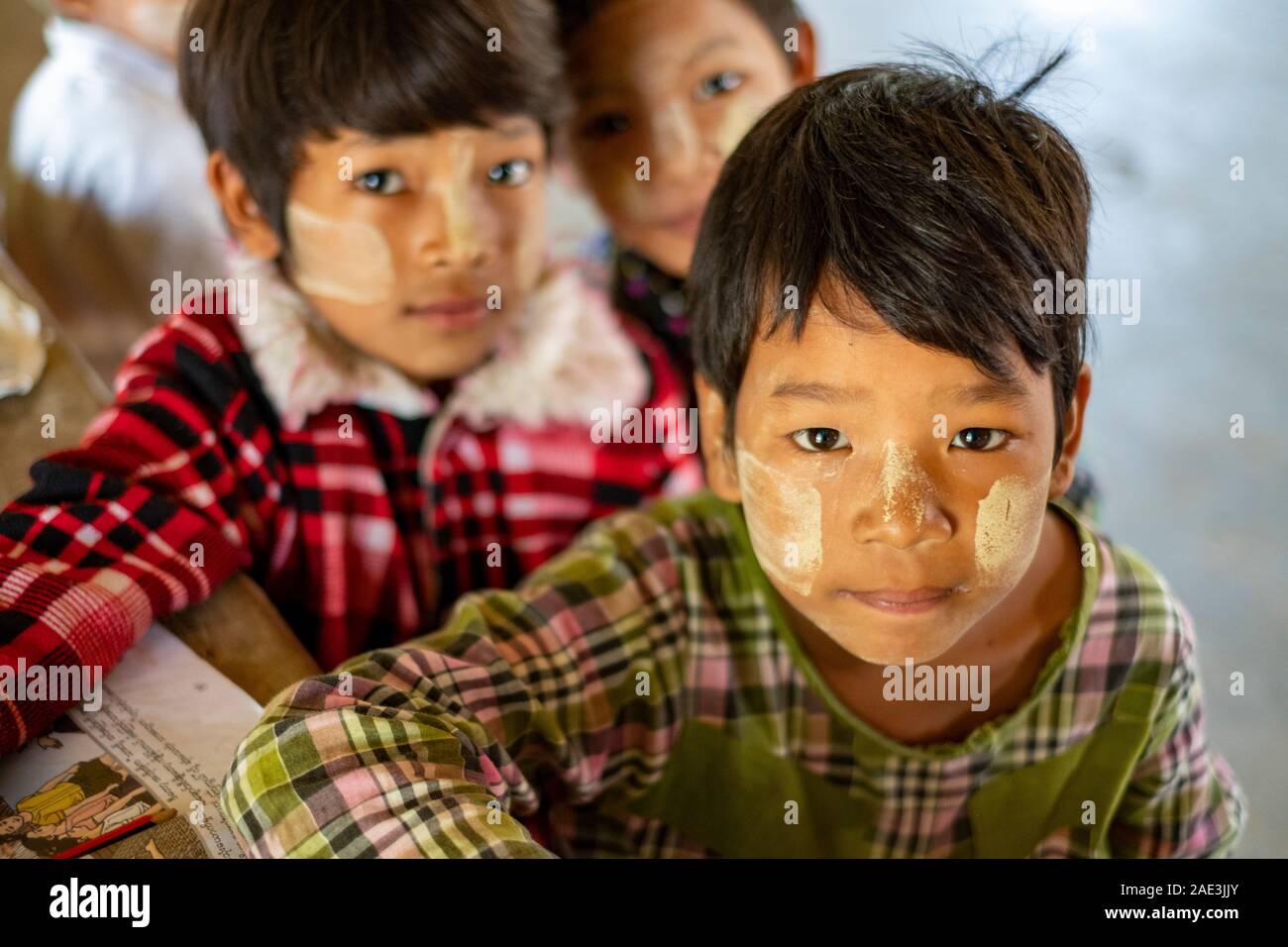Junge Studenten in einer burmesischen Schule in einem ländlichen Dorf entlang der Chindwin Fluss, Myanmar (Birma) mit Gepuderten gesichter sie vor der Sonne zu schützen Stockfoto