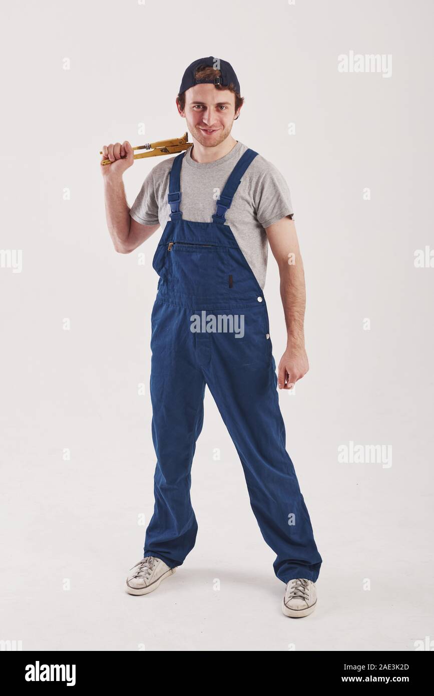 Vorderansicht. Mann in der blauen Uniform steht vor weißem Hintergrund im Studio Stockfoto