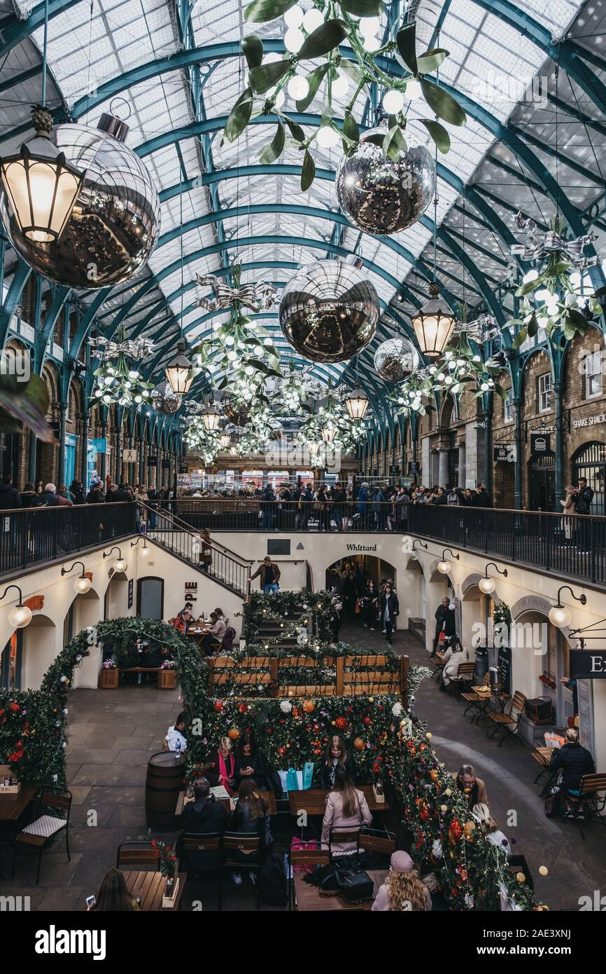 London, Großbritannien - 24 November, 2019: Weihnachtsschmuck in Covent Garden Market, eine der beliebtesten Touristenattraktionen in London, Menschen im Café Stockfoto