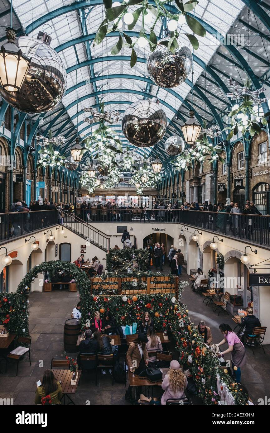 London, Großbritannien - 24 November, 2019: Weihnachtsschmuck in Covent Garden Market, eine der beliebtesten Touristenattraktionen in London, Menschen im Café Stockfoto