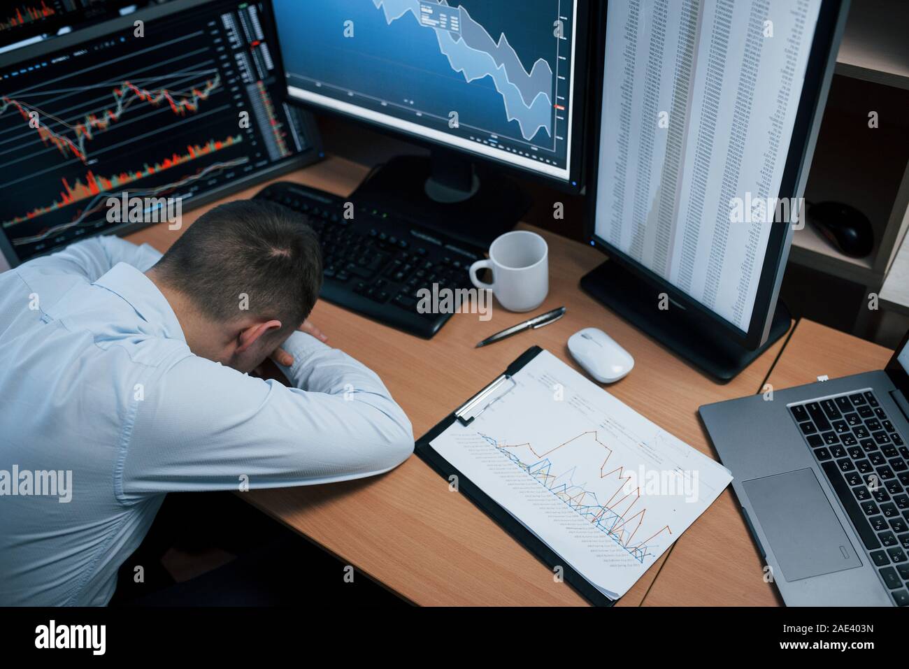 Psychische Gesundheit Konzeption. Moderne Angst und Stress. Mann online arbeiten im Büro mit mehreren Bildschirmen in Index charts Stockfoto