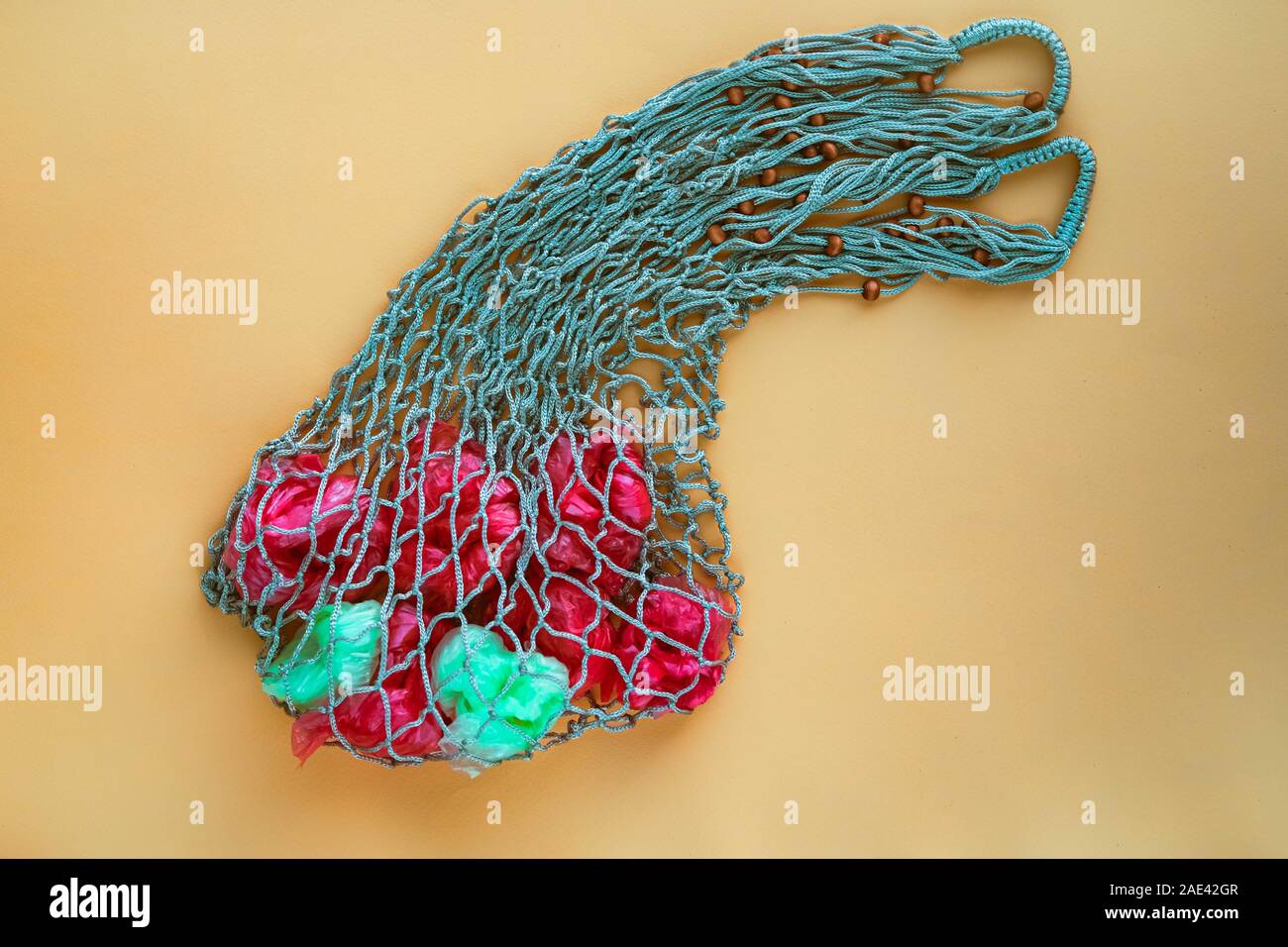 Net Tasche voll von künstlichen Früchten von grünen und roten Plastiktüten. Keine Kunststoff-Konzept. Umweltprobleme. Stockfoto