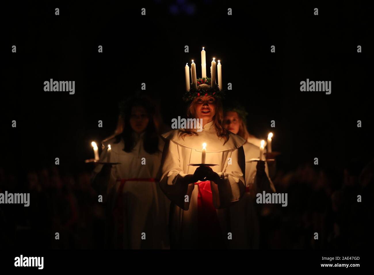 Matilda Bergstrom eine Krone trägt der Kerzen symbolisieren St Lucy, führt ein Abendessen bei Kerzenschein Prozession der London Nordic Chor während der Sankta Lucia service an der York Minster. Bild Datum: Freitag Dezember 6, 2019. Die atmosphärischen Schwedische Service ist eine Feier der St. Lucy, ein sizilianisches mädchen für ihren christlichen Glauben im vierten Jahrhundert den Märtyrertod. Die Krone symbolisiert ein Halo, einer roten Schärpe ihr Martyrium und der Service feiert das Mitbringen von Licht in der Dunkelheit des Winters. Photo Credit: Danny Lawson/PA-Kabel Stockfoto