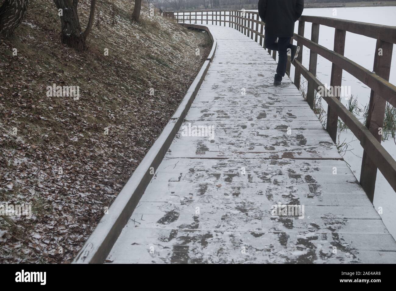Man Walking auf zugefrorenen Teich von City Park Stockfoto