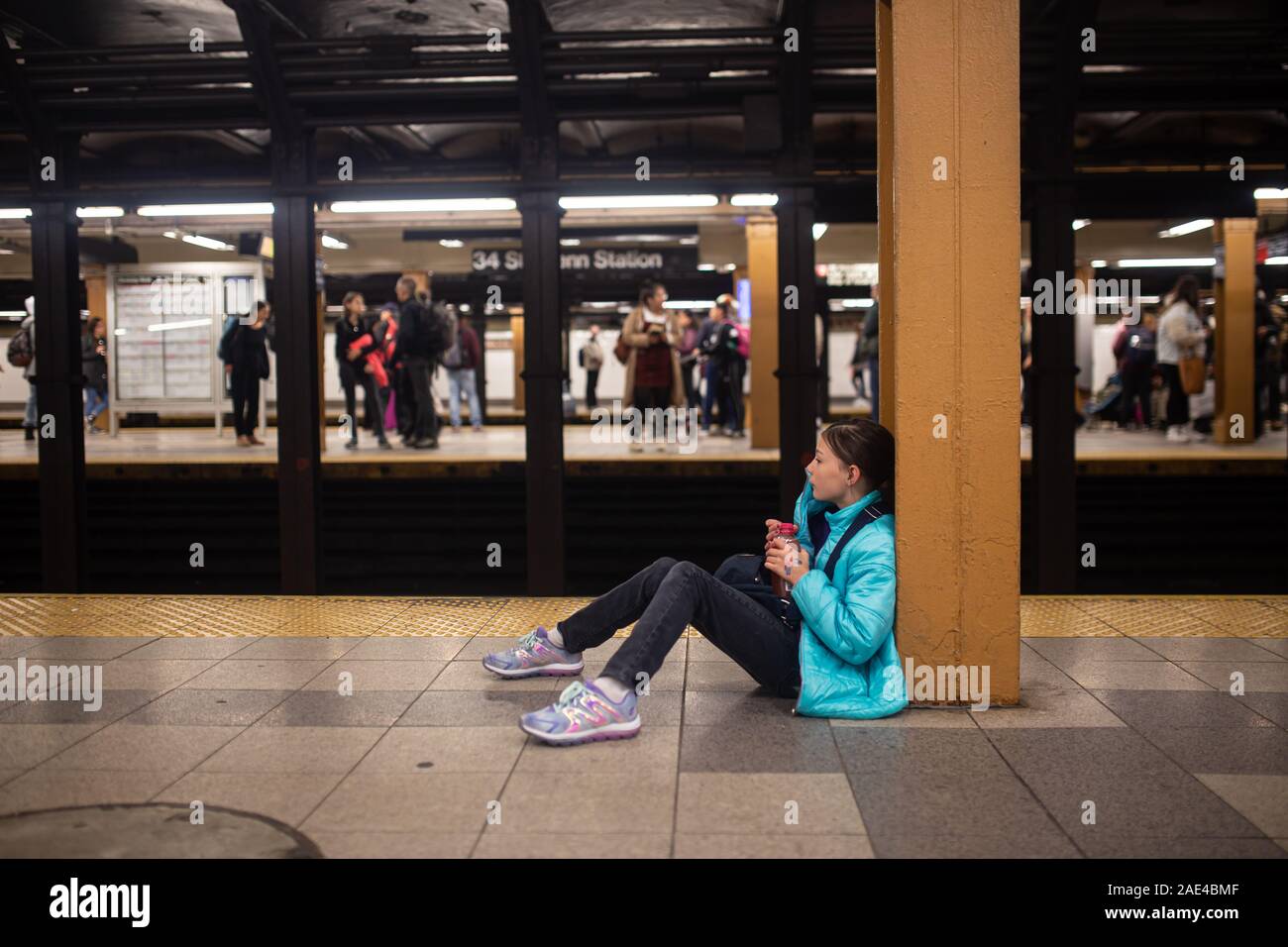 Tween girl Warten auf die U-Bahn in New York City zu gelangen Stockfoto