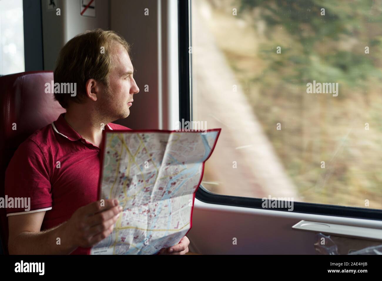 Ein lächelnder Mann in eine S-Bahn Studien die Karte Stockfoto