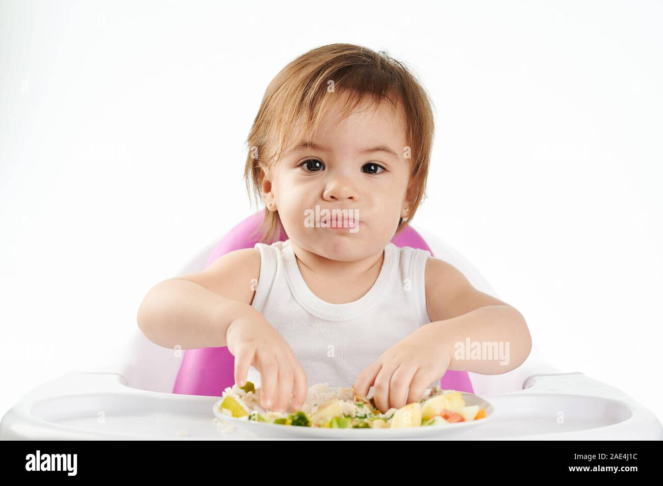Funny Face von Baby Mädchen mit Essen auf weißem Hintergrund Stockfoto