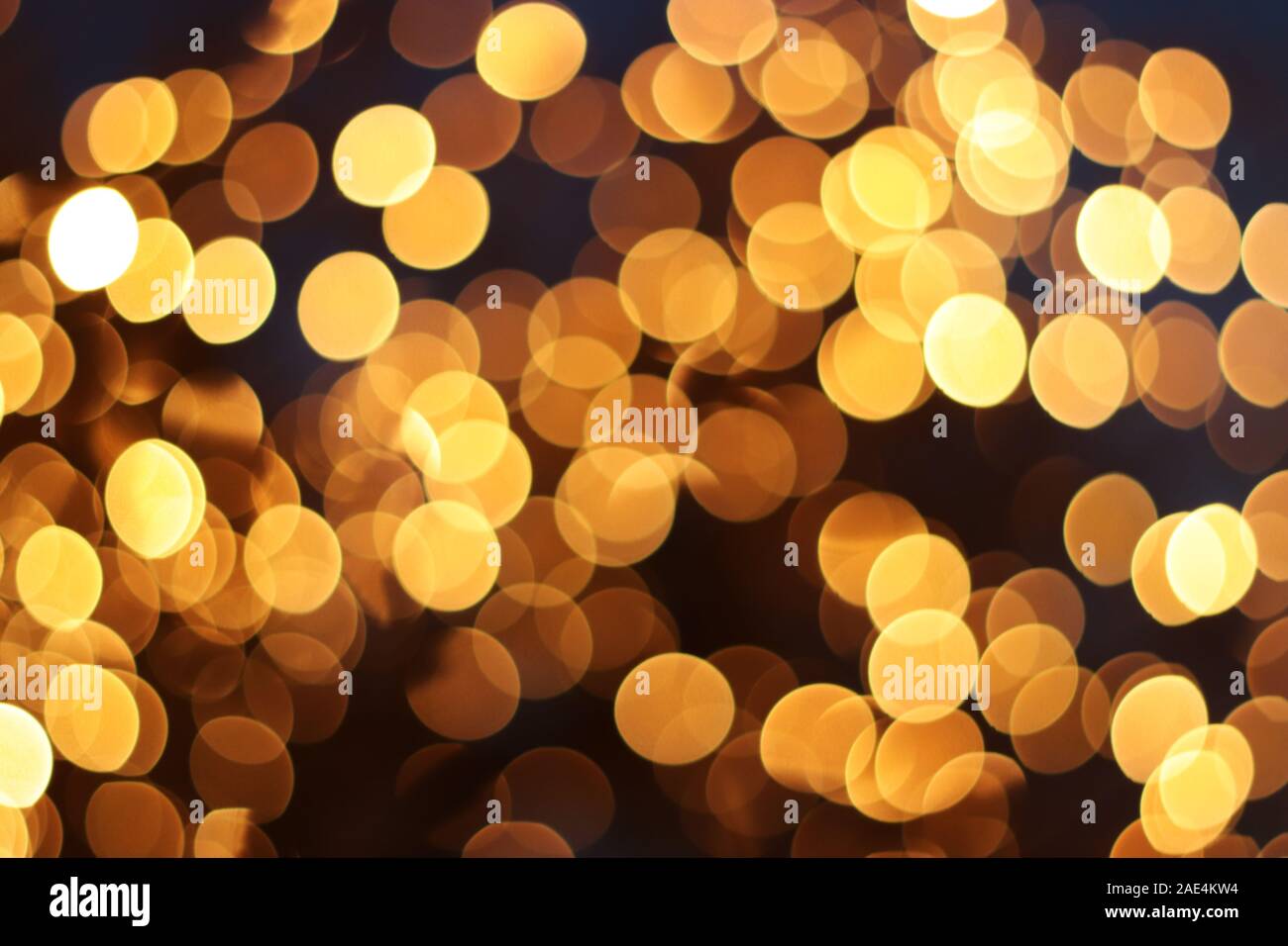 Hintergrund mit goldfarbenen Defokussierten bokeh Lichter im Dunkeln Stockfoto