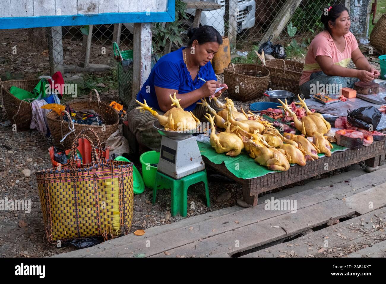 Reifen erwachsenen burmesischen Frau verkauft die ganze frische Hähnchen auf einem Markt in Homalin Stall, Nordwesten Myanmar (Birma) Stockfoto