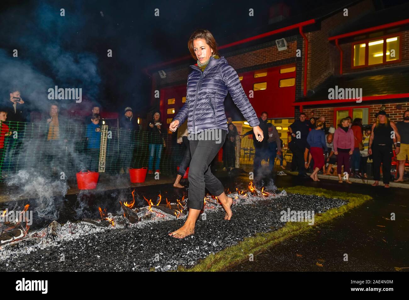 Bridport, Dorset, Großbritannien. 6. Dezember 2019. Mitglieder der öffentlichkeit gehen über glühende Kohlen, wie Sie an eine Wohltätigkeitsorganisation firewalk bei Bridport Gemeinschaft Feuerwache in Dorset zugunsten der Feuerwehrleute Charity. Foto: Graham Jagd-/Alamy Leben Nachrichten. Stockfoto