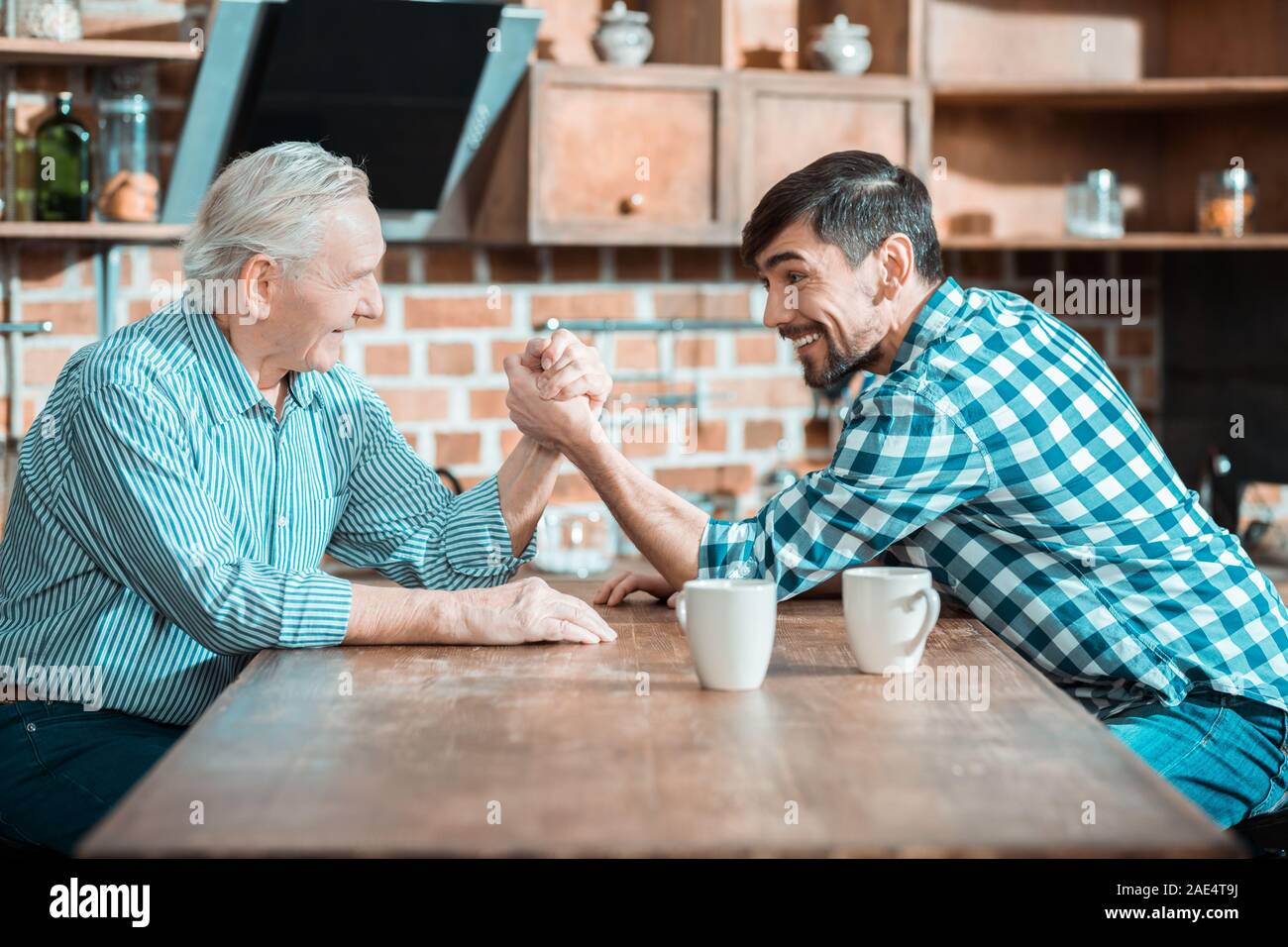 Happy Vater und Sohn tun, Arm Wrestling Stockfoto